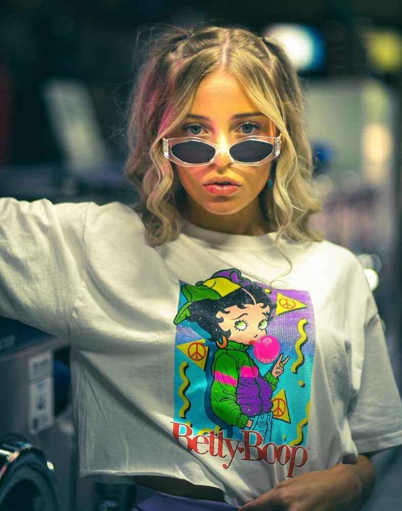Young woman in sunglasses standing in laundromat